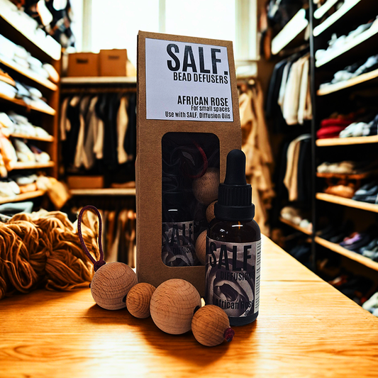 SALF. bead defusers and bottle on a wooden surface with shelves in the background