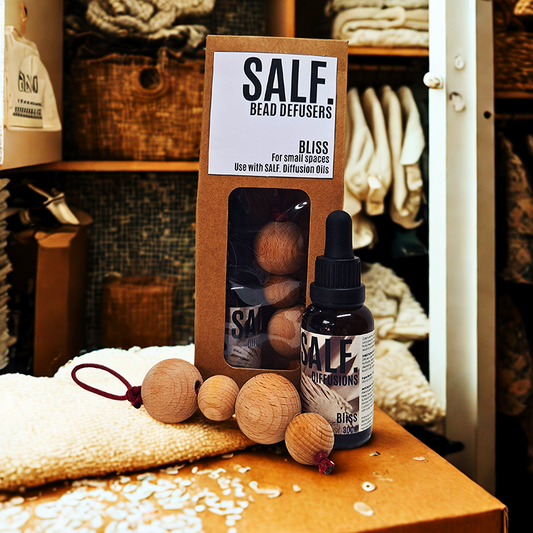 SALF. packaged Defuser Beads standing on a counter in a closet space with a set of 4 beads and diffusion scent in a bottle